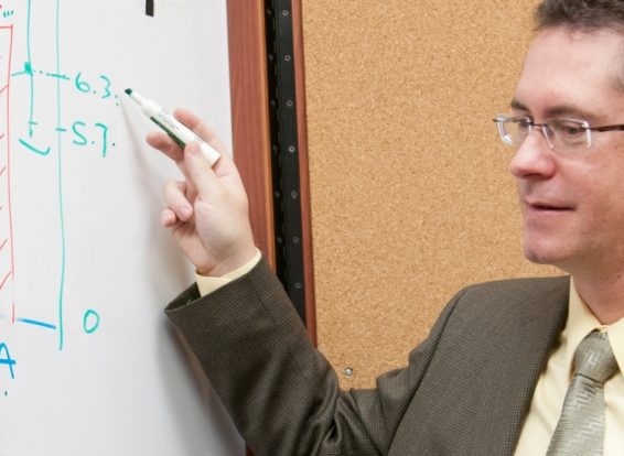 Faculty writing on white board