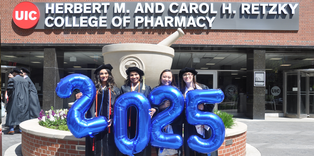 Students hold blue balloons that say 